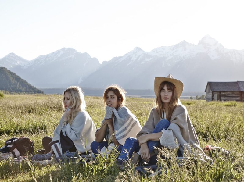 three girls sitting in a field