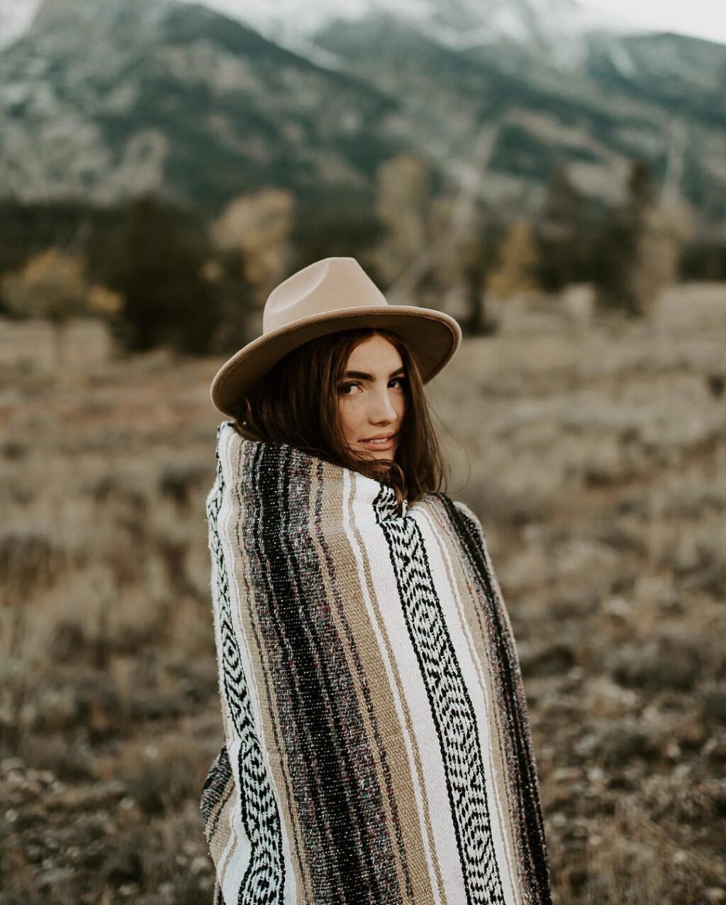 girl wrapped in blanket in the mountains