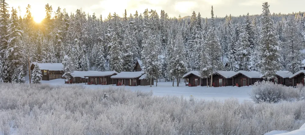 Log cabins a Turpin Meadow Ranch covered in snow.