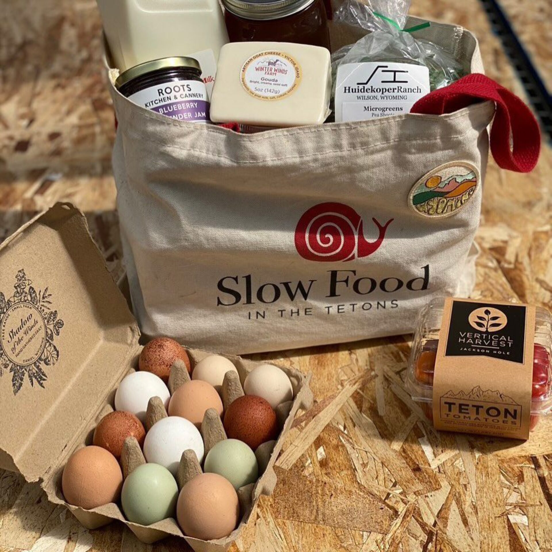 A canvas grocery bag filled with provisions, next to a carton of eggs.