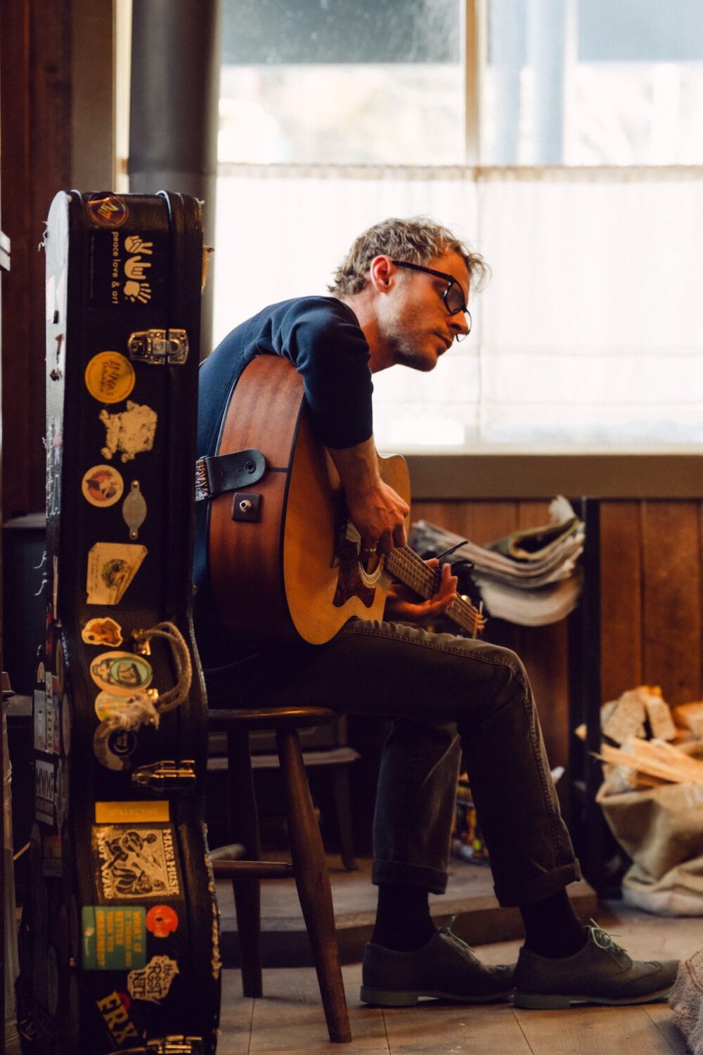 A man playing the guitar and signing.