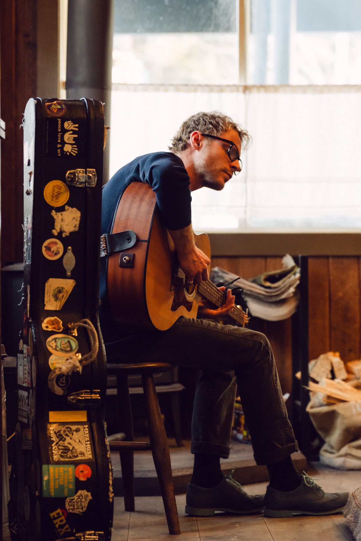 A man playing the guitar and signing.