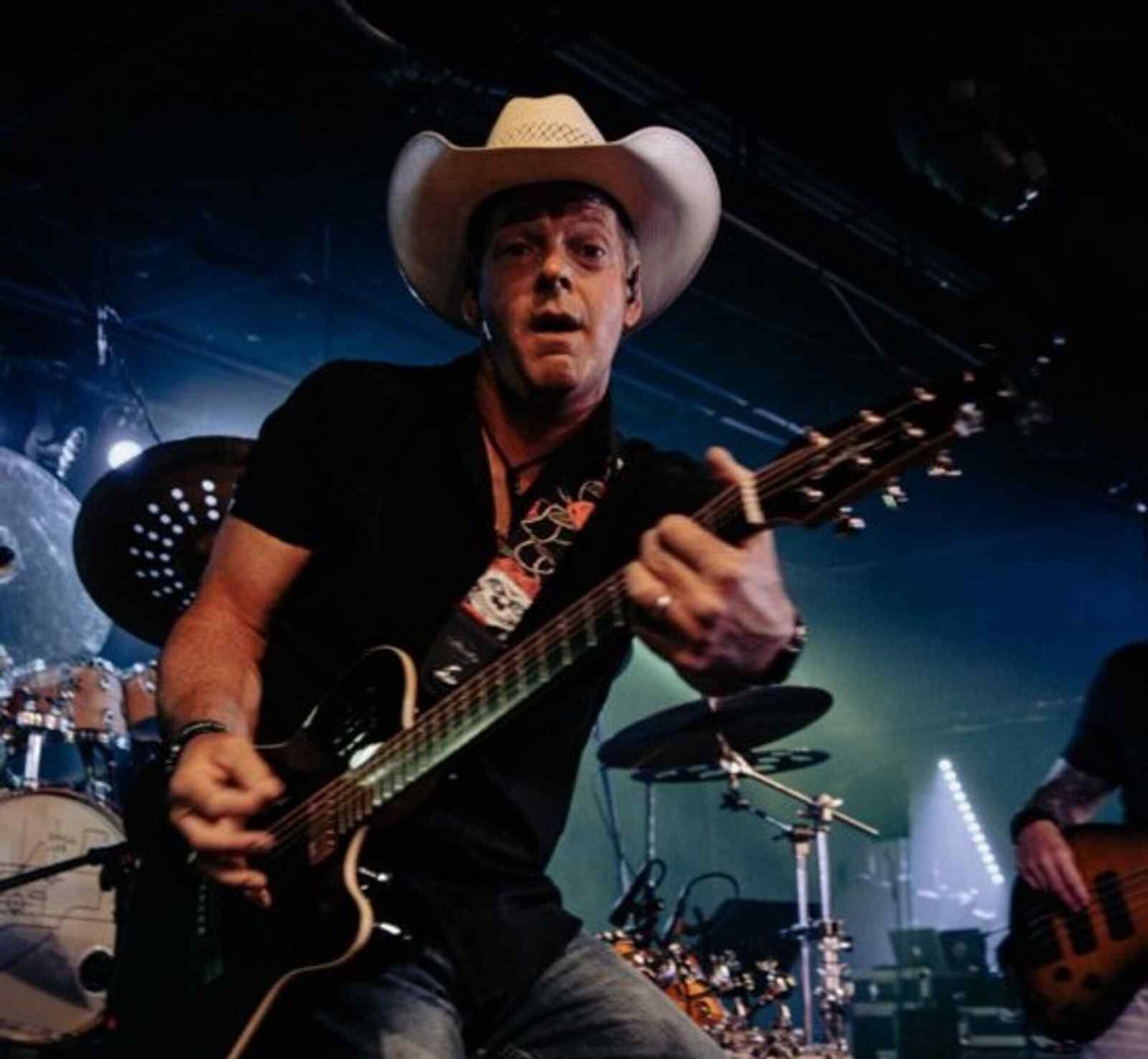 The musician Triple Nickle playing a guitar on a stage.