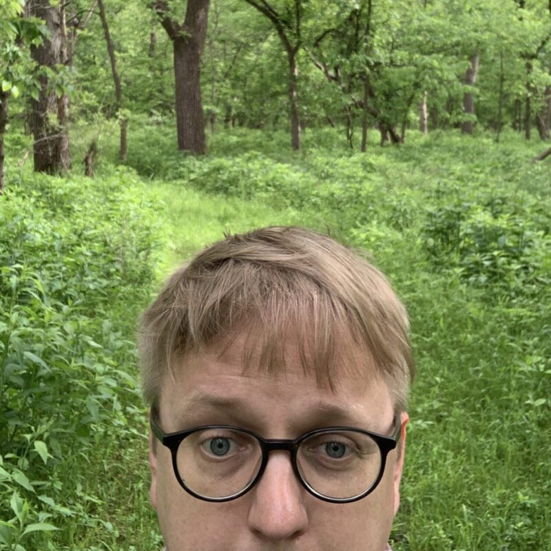 Artist Nolan Tredway in a lush forest.