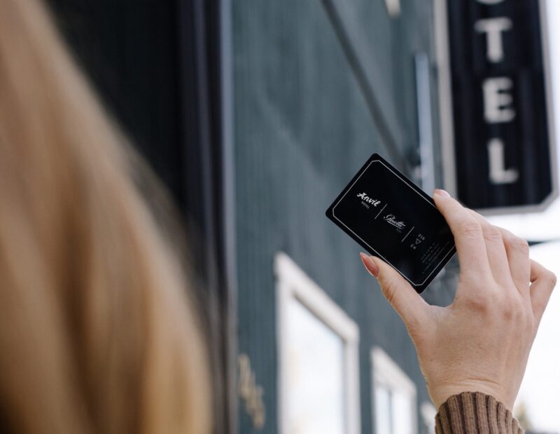 A woman holding an Anvil Hotel room key.