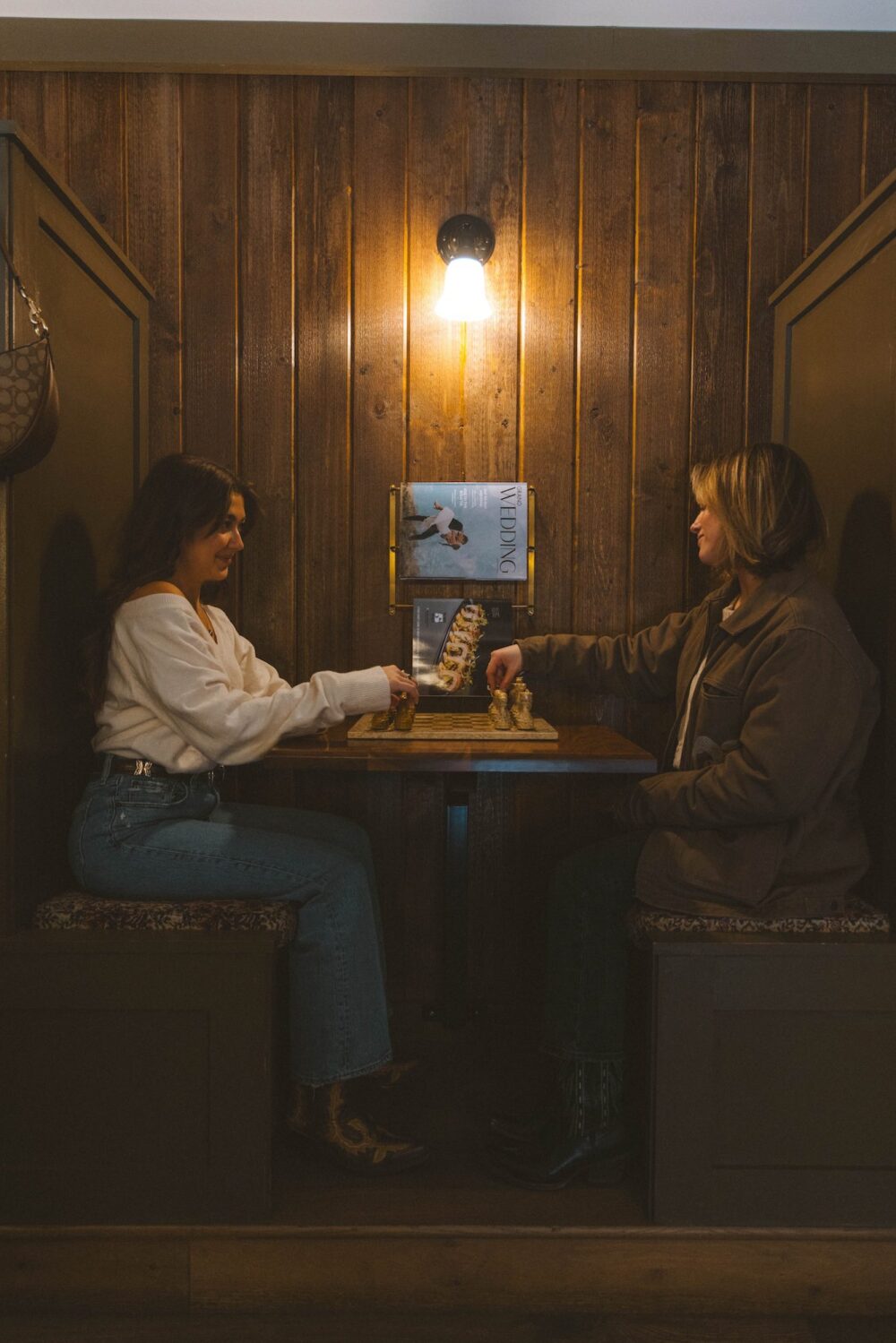 Two women playing chess in the lobby of Anvil Hotel Jackson.