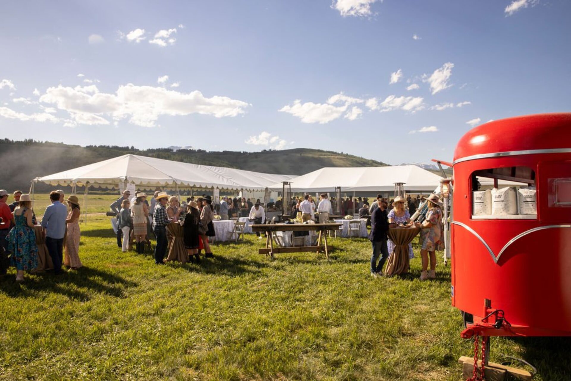 Outdoor tents and people gathering at Jackson Hole Food & Wine Summer Festival.